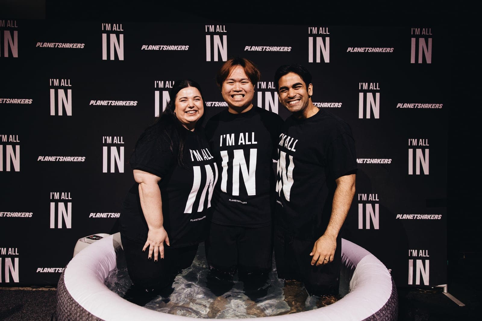 Me at my baptism, standing in the baptism pool with two others, all smiling